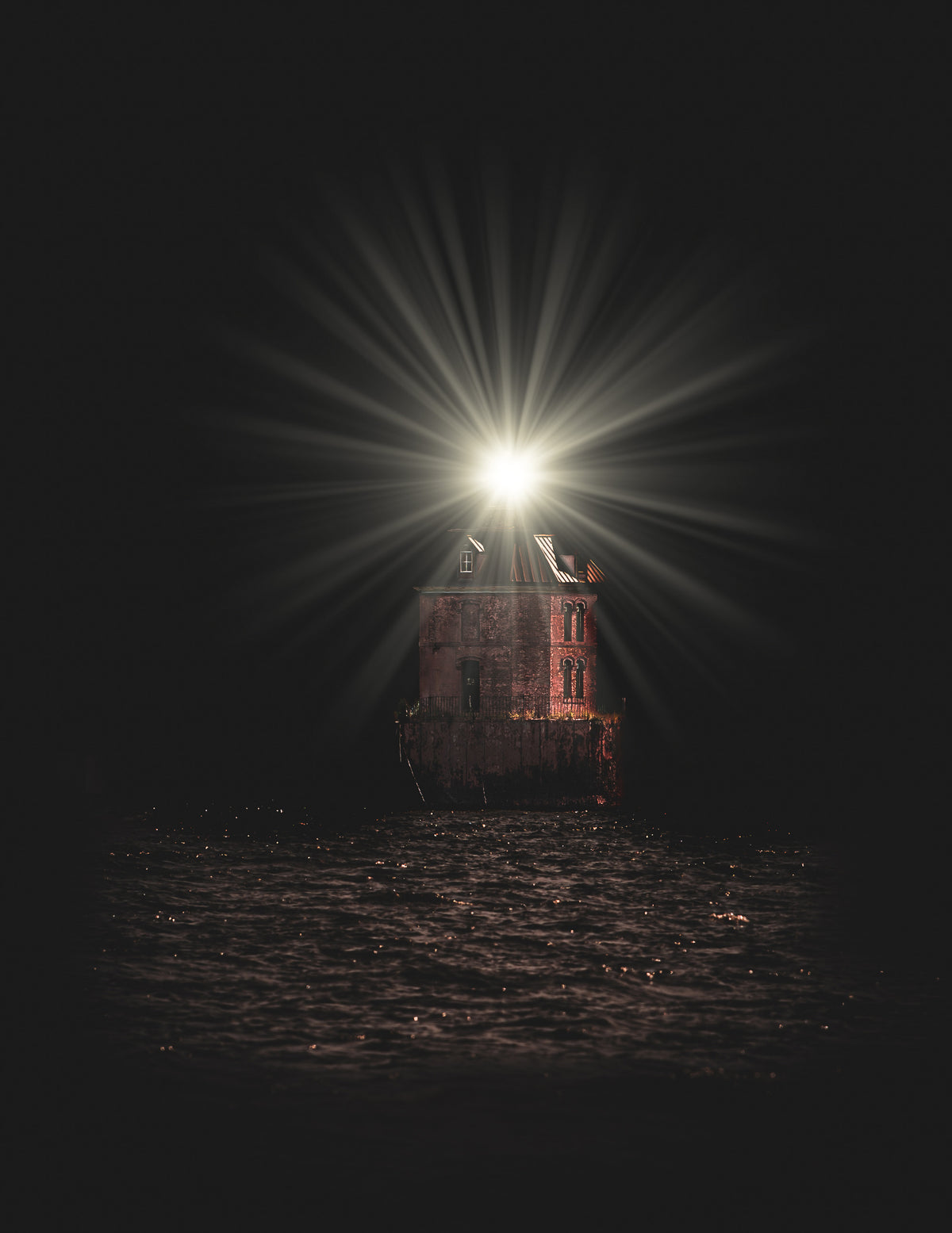 Cinematic night photography of a stone lighthouse with a brilliant light beam over dark water.