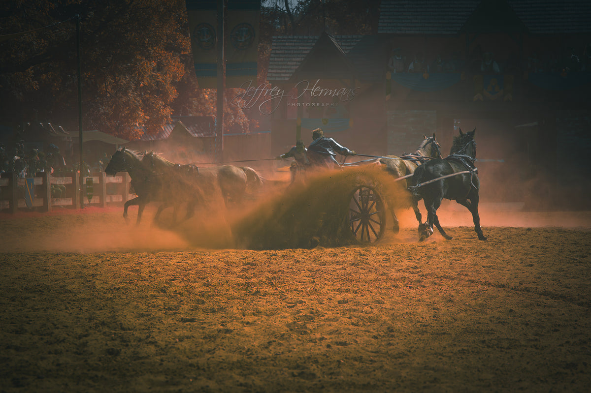 Cinematic photography of a horse-drawn carriage racing through dust in an arena.